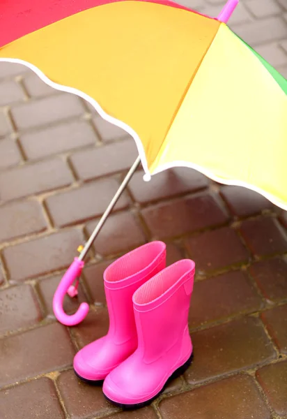 Bunter Regenschirm und Gummistiefel — Stockfoto