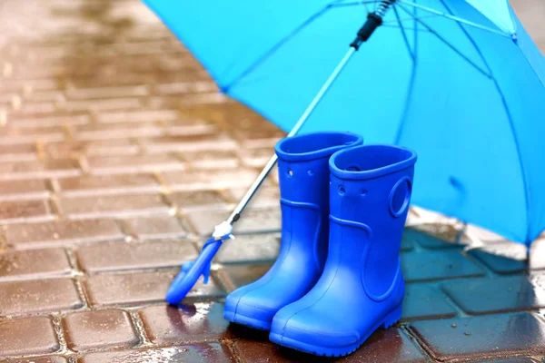 Blue umbrella and gumboots — Stock Photo, Image