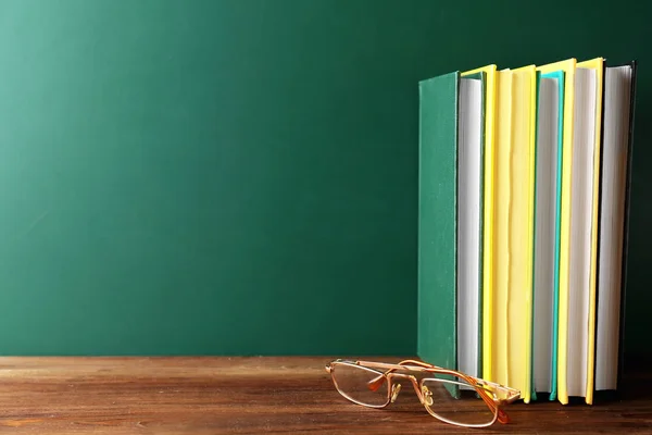 Nieuwe kleurrijke boeken en glazen — Stockfoto