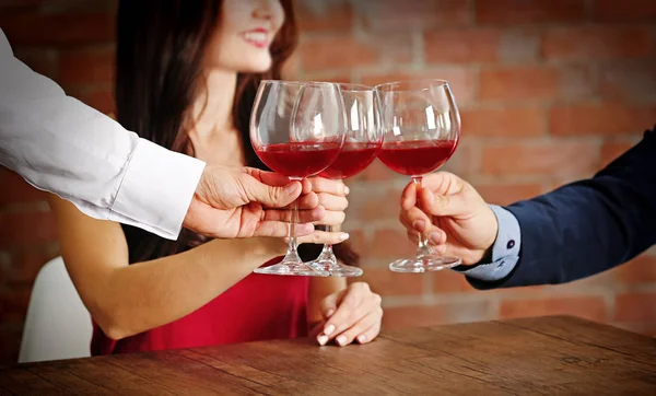 People toasting with glasses of red wine