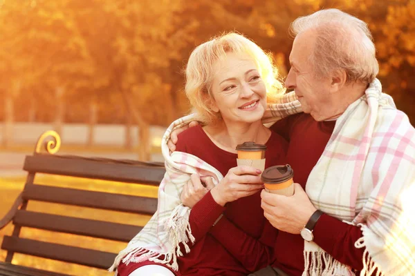 Casal maduro com café no parque de outono — Fotografia de Stock