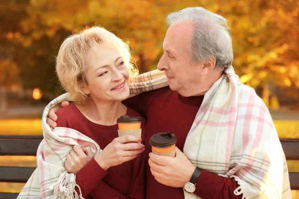 Зріла пара з кавою в осінньому парку — стокове фото