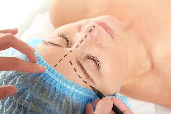 Surgeon hands drawing marks on female face for plastic operation — Stock Photo, Image