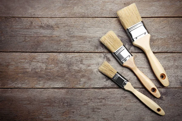 Paint brushes on wooden table — Stock Photo, Image