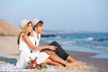 mutlu çift sahilde oturmuş