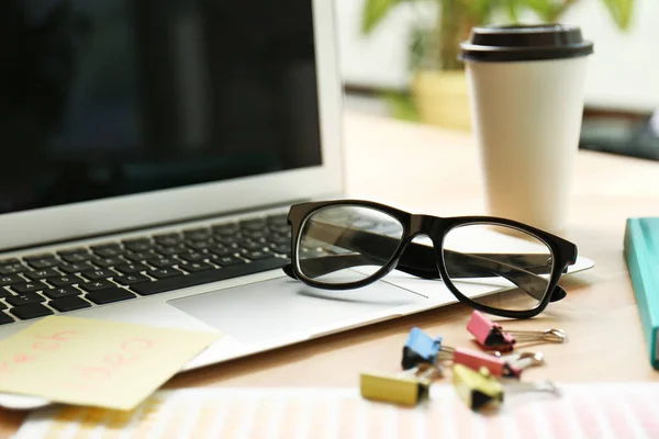 Lugar de trabajo con portátil y anteojos — Foto de Stock