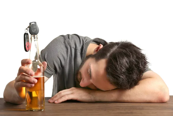 Ung berusad man med bilnyckel och flaska öl på grå bakgrund — Stockfoto