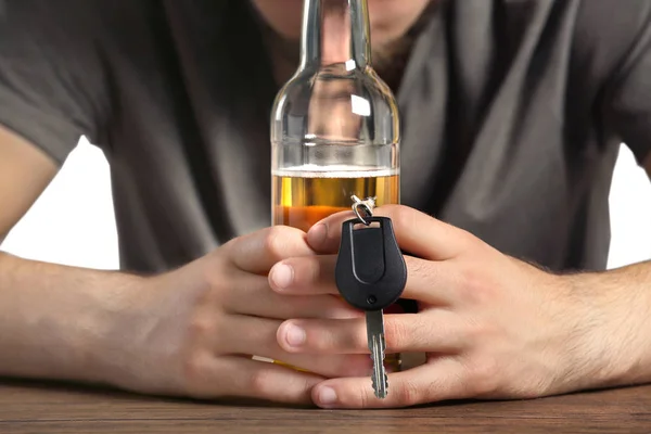 Manos con botella de cerveza y llave del coche — Foto de Stock