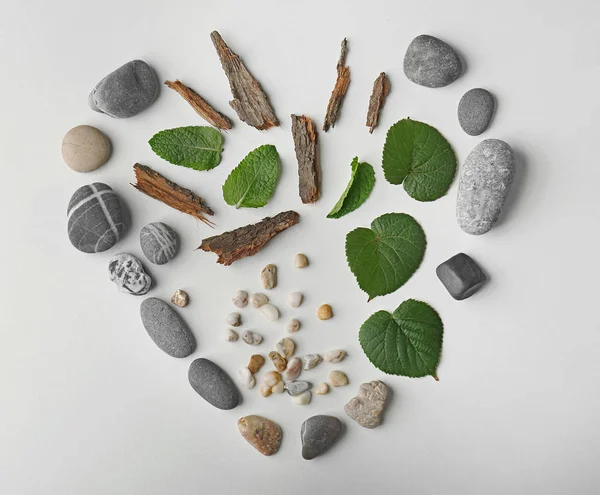 Heart of leaves with pebbles and pieces of bark — Stock Photo, Image