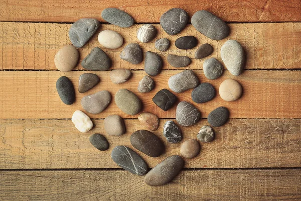 Hermoso corazón de guijarros sobre fondo de madera — Foto de Stock