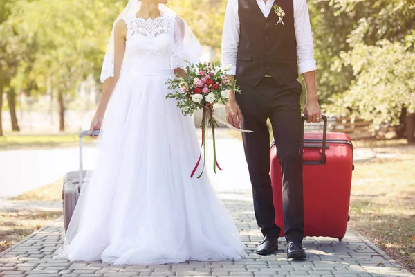 Braut und Bräutigam mit großen Koffern — Stockfoto