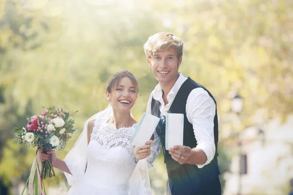 Bruid en bruidegom met kaartjes in park — Stockfoto