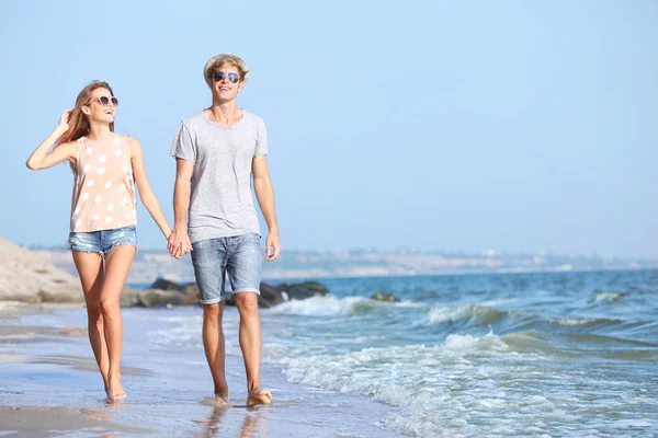 Paar geht am Strand spazieren — Stockfoto