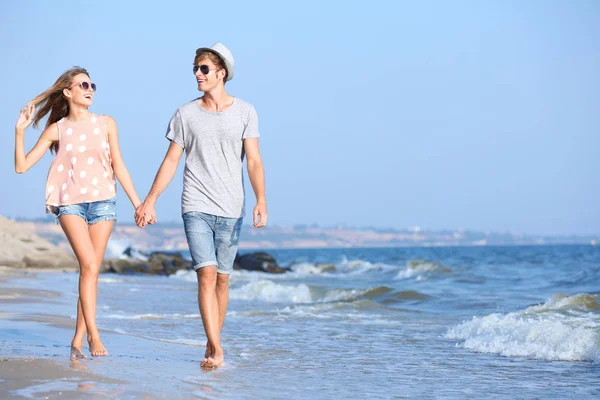 Pareja caminando en la orilla del mar — Foto de Stock