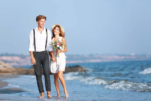 Happy couple walking on seashore — Stock Photo, Image