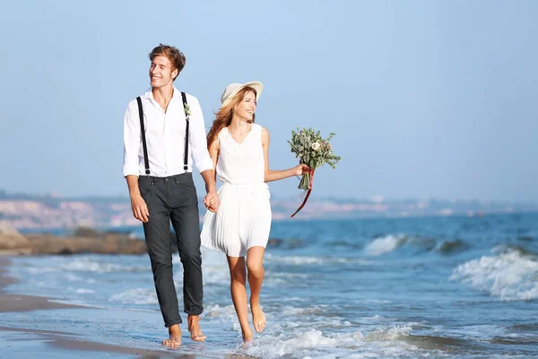 Happy couple walking on seashore — Stock Photo, Image