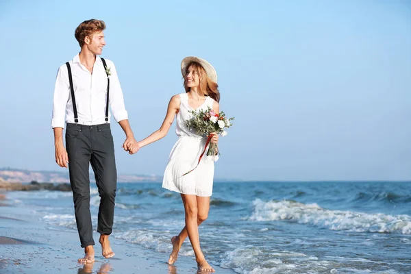 Happy couple walking on seashore — Stock Photo, Image