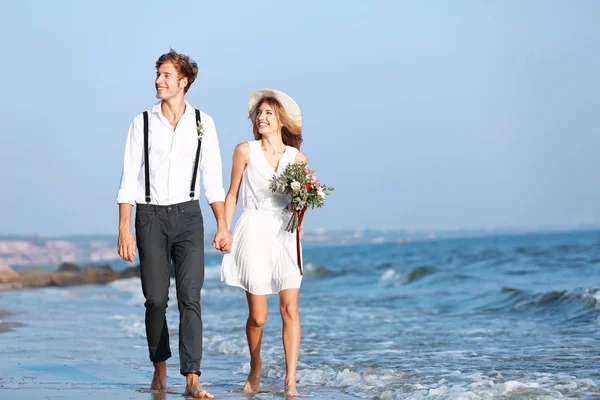 Happy couple walking on seashore — Stock Photo, Image