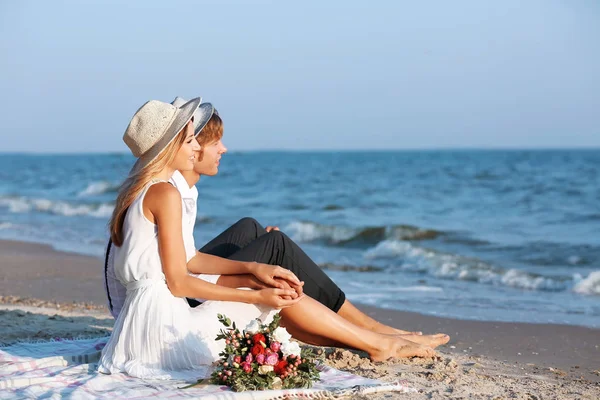 幸福的情侣坐在海滩上 — 图库照片