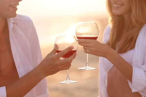 Ouple het drinken van rode wijn aan kust — Stockfoto