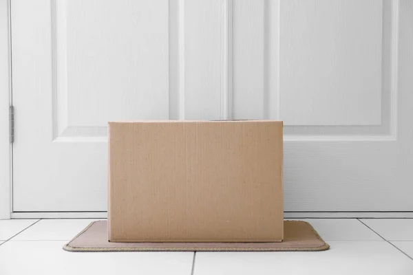 Cardboard box on rug — Stock Photo, Image