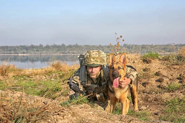 Soldier with german shepherd dog at military firing range