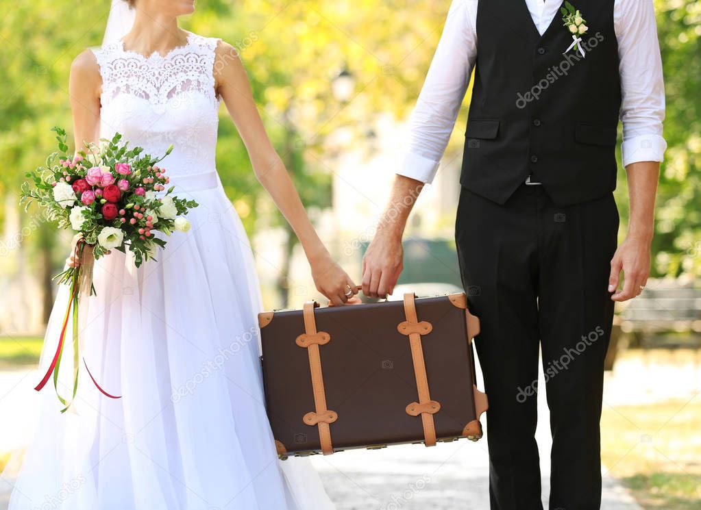 Groom and bride with vintage suitcase