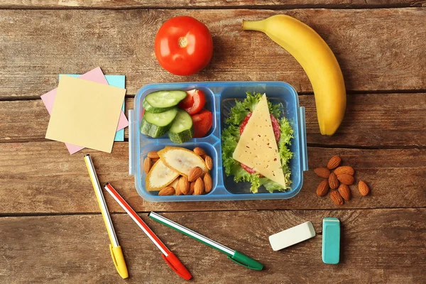 Lunch box with food and stationery — Stock Photo, Image