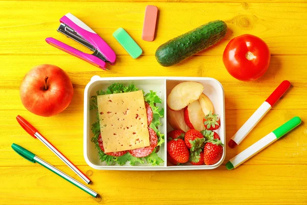 Lunch box with food and stationery — Stock Photo, Image