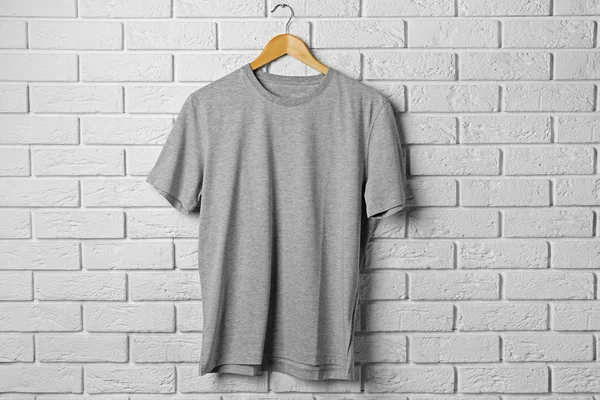 gray t-shirt against brickwall