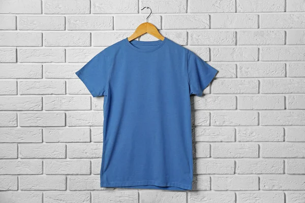 T-shirt azul contra tijolo — Fotografia de Stock