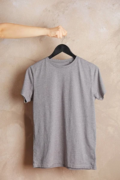 Grijs t-shirt tegen grunge muur — Stockfoto
