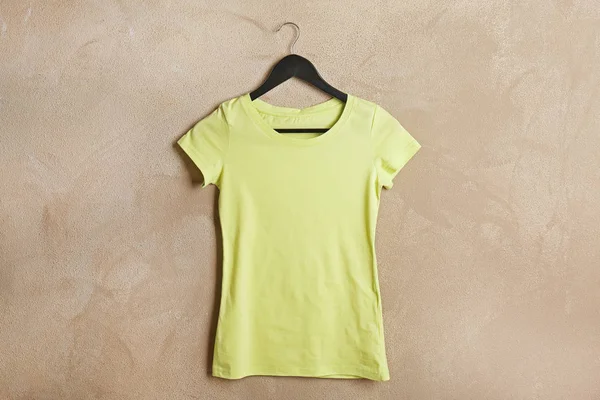 Yellow t-shirt against grunge wall — Stock Photo, Image