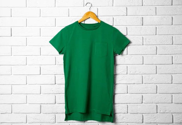 T-shirt verde contra tijolo — Fotografia de Stock