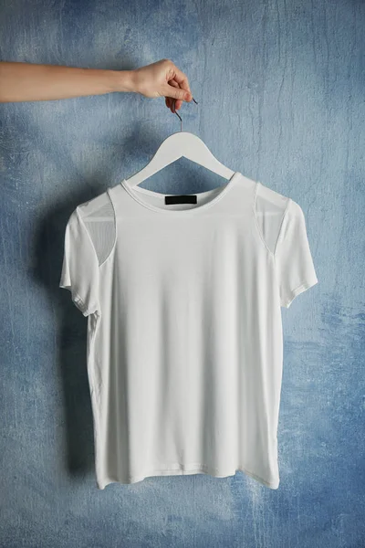 White t-shirt against grunge wall — Stock Photo, Image