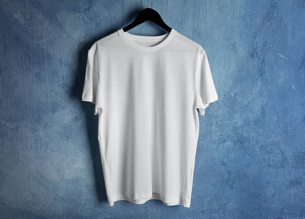 White t-shirt against grunge wall — Stock Photo, Image