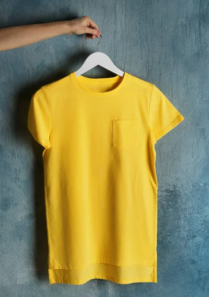 yellow t-shirt against grunge wall