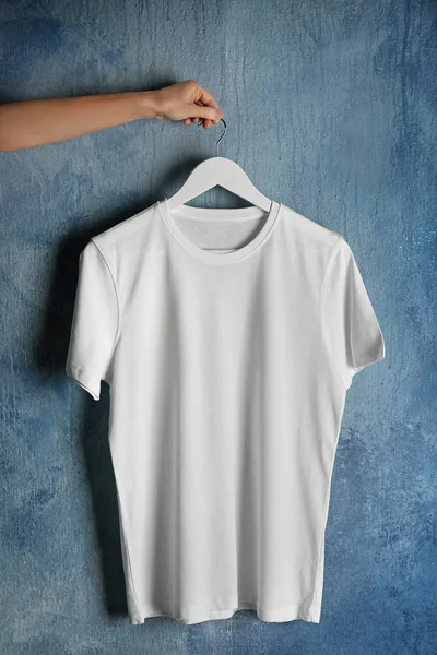 White t-shirt against grunge wall — Stock Photo, Image