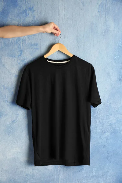 black t-shirt against grunge wall