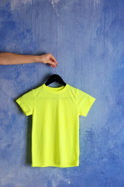 Yellow t-shirt against grunge wall — Stock Photo, Image