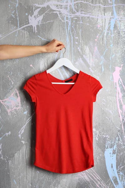 Red t-shirt against grunge wall — Stock Photo, Image