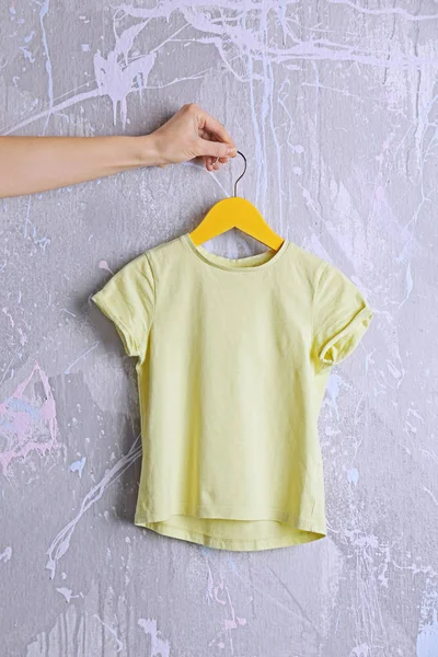 yellow t-shirt against grunge wall