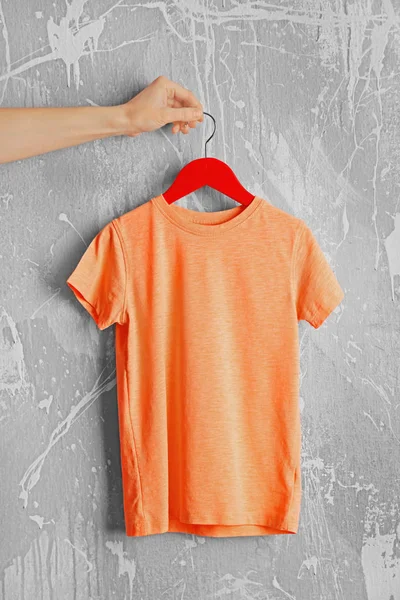 orange t-shirt against grunge wall