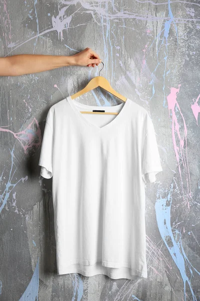 White t-shirt against grunge wall — Stock Photo, Image