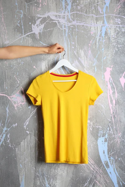 yellow t-shirt against grunge wall