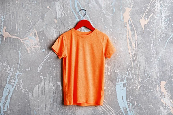 Pomarańczowy t-shirt ścianę grunge — Zdjęcie stockowe
