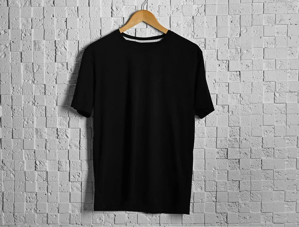 black t-shirt against brickwall