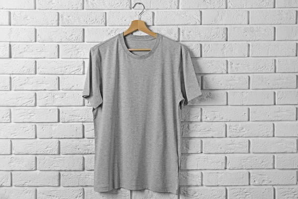 gray t-shirt against brickwall