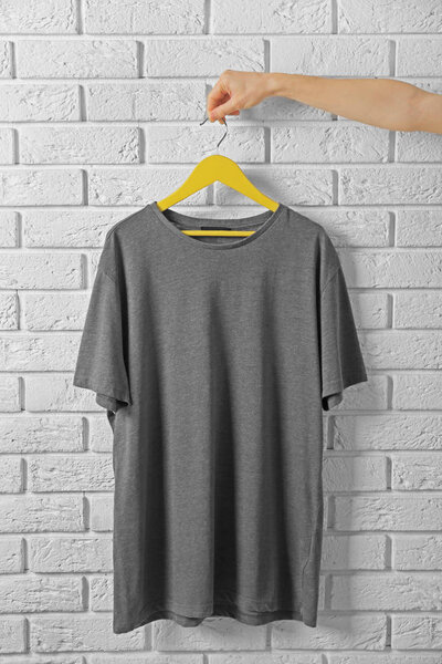 серая футболка против кирпичной стены
