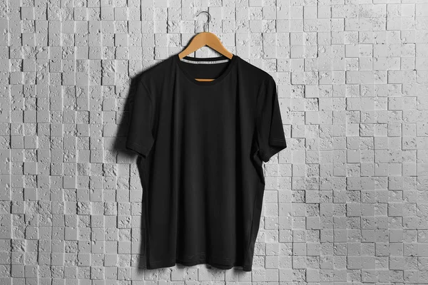 black t-shirt against brickwall